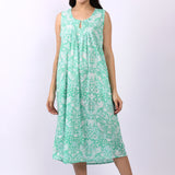 Woman wearing sleeveless cotton nightdress in spearmint green with Strawberry Thief print, keyhole neckline, and relaxed fit.