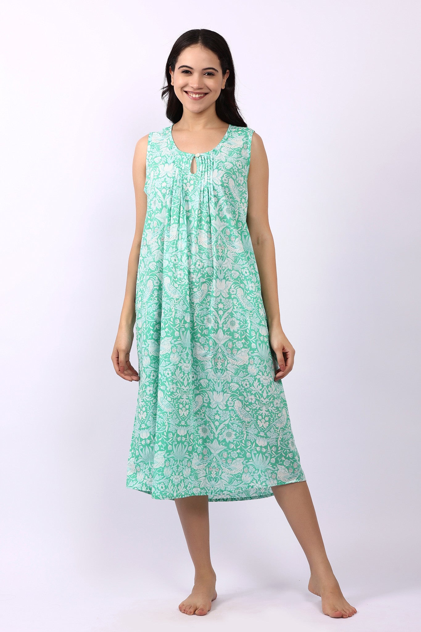 Woman wearing sleeveless cotton nightdress in spearmint green with Strawberry Thief print, keyhole neckline, and relaxed fit.