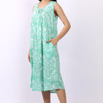 Woman wearing sleeveless cotton nightdress in spearmint green with Strawberry Thief print, keyhole neckline, and relaxed fit.