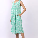 Woman wearing sleeveless cotton nightdress in spearmint green with Strawberry Thief print, keyhole neckline, and relaxed fit.