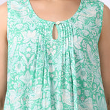 Woman wearing sleeveless cotton nightdress in spearmint green with Strawberry Thief print, keyhole neckline, and relaxed fit close up of pin tuck details.