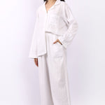 Side profile of Lotus Jacqui long cotton pyjama set in white self-stripe with side pocket detail.