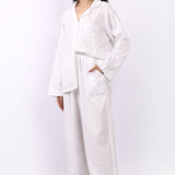Side profile of Lotus Jacqui long cotton pyjama set in white self-stripe with side pocket detail.