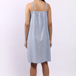Woman wearing a light blue nightgown with thin straps on a white background