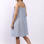 Woman wearing a light blue dress with thin straps on a white background