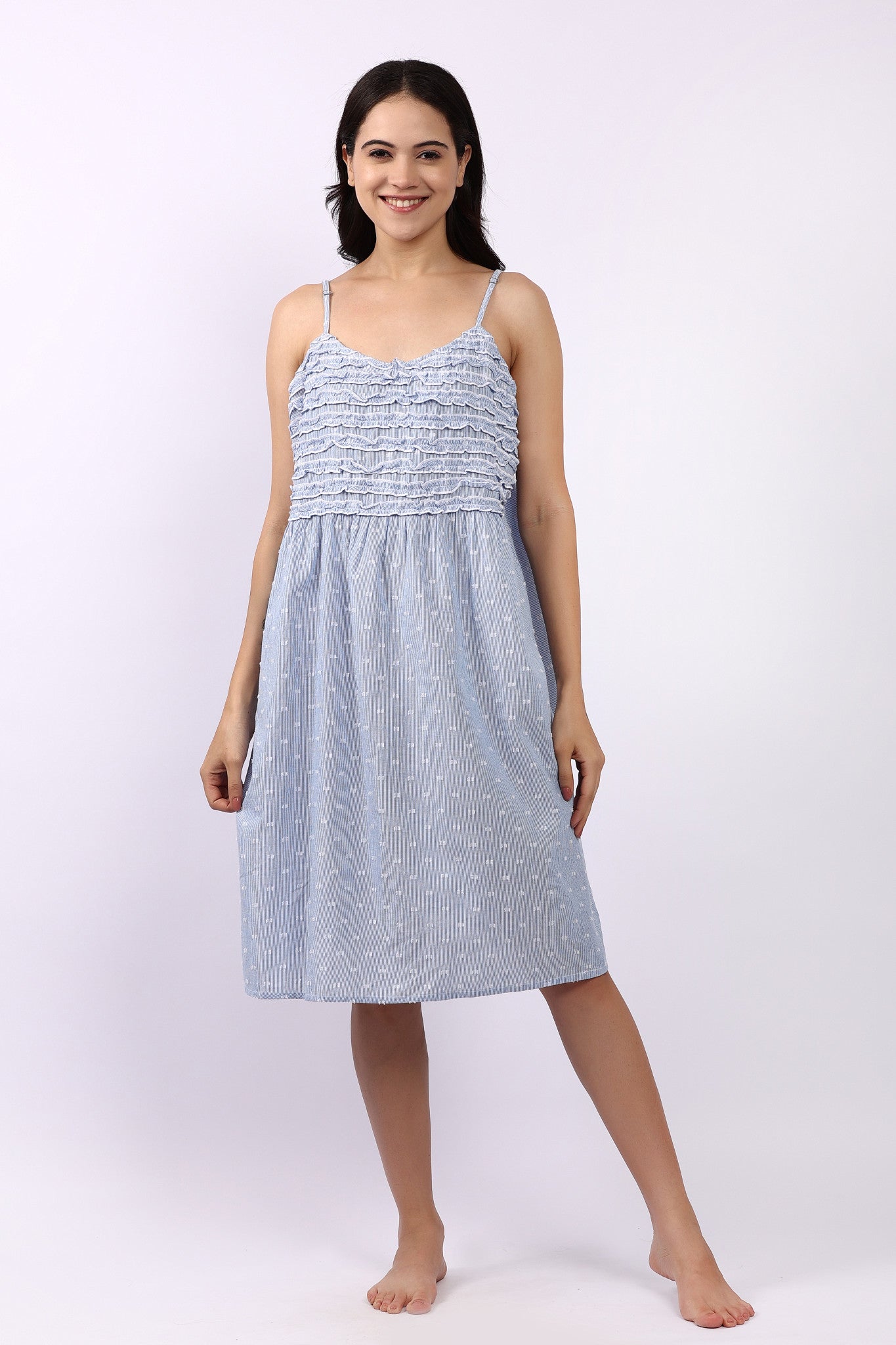 Woman wearing a light blue dress with thin straps on a white background