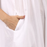 Side profile of Lotus Susie white cotton nightdress with slim straps, pintuck detail and hidden pockets.