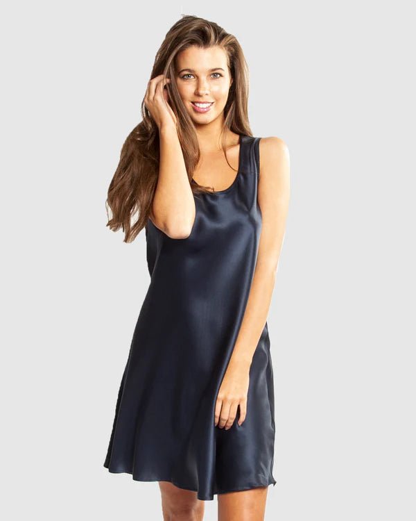 Model wearing Mono Silk Short Nightie in navy, featuring a flattering low neckline, wide straps, and a draped silk finish just above the knee.