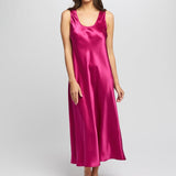 Model wearing cerise silk long nightie with scoop neck and wide straps, cut on the bias for an elegant drape.