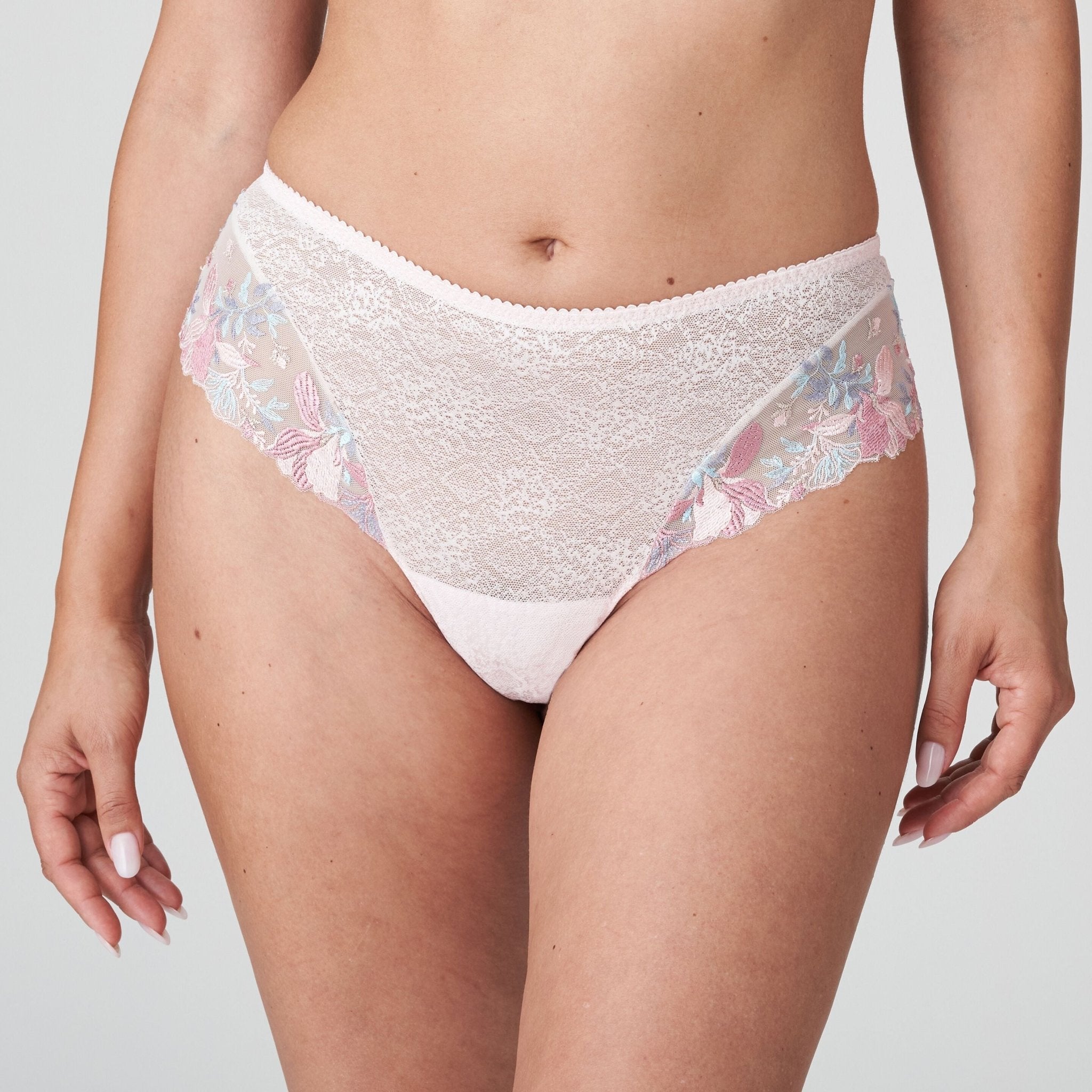Model wearing the Mohala Luxury Thong Brief pastel pink by The Foundation, showcasing feminine lace and romantic embroidery details