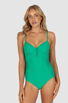 Woman wearing a green swimsuit on a gray background