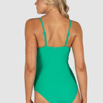 Woman wearing a green swimsuit on a light gray background back view