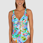 Woman wearing a colorful floral swimsuit on a white background