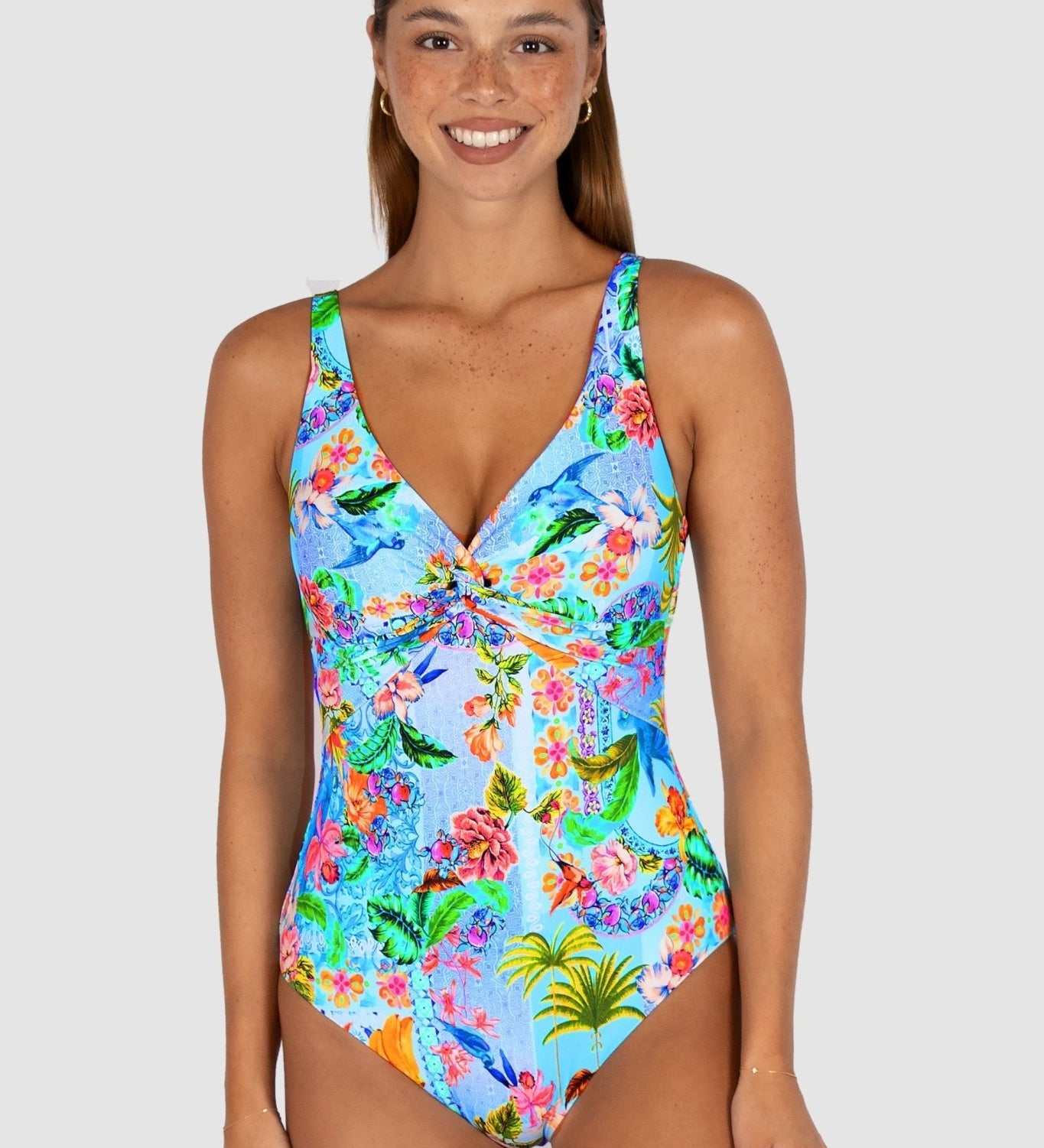 Woman wearing a colorful floral swimsuit on a white background