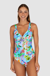 Woman wearing a colorful floral swimsuit on a white background