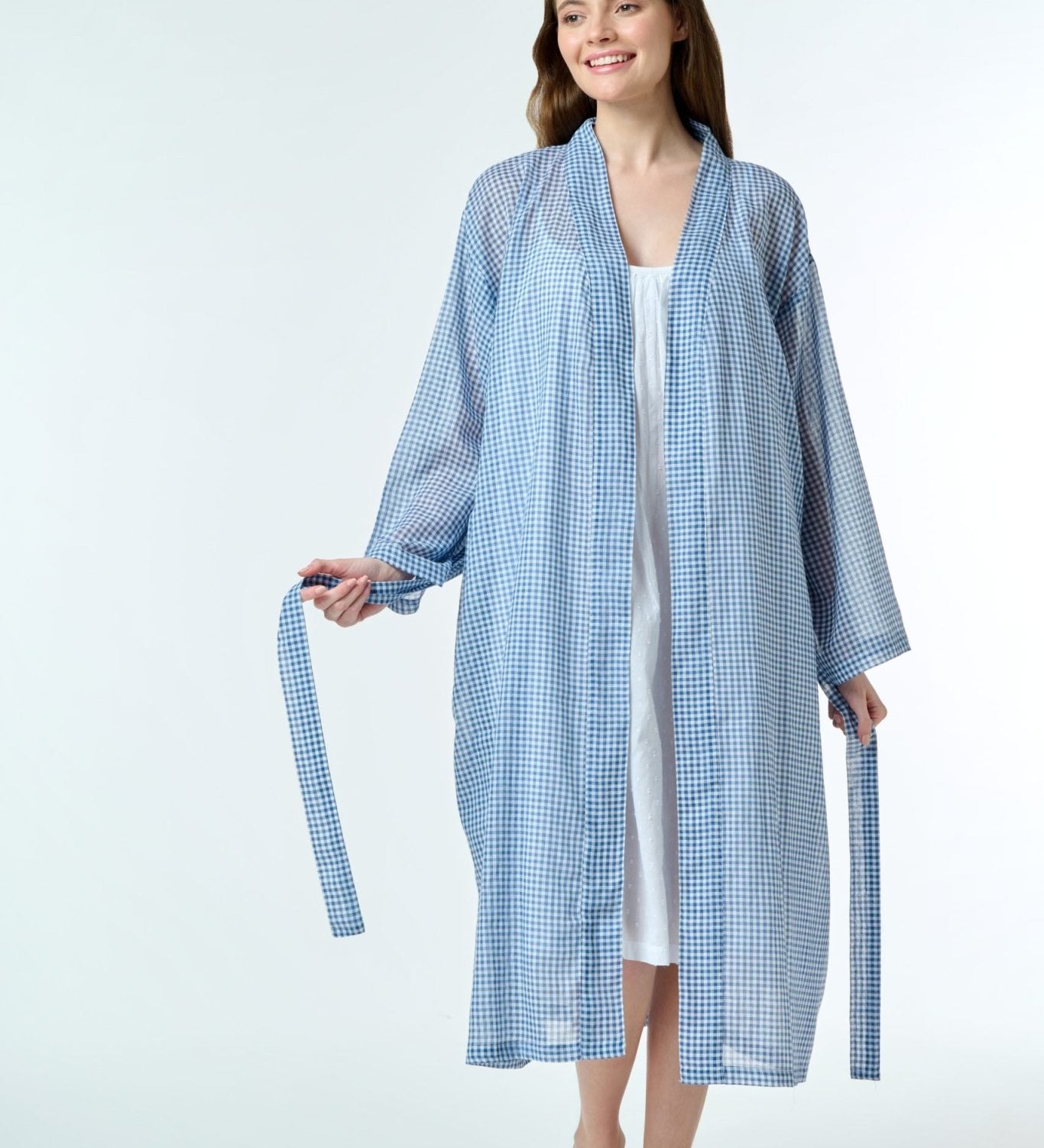Model wearing Hand Loomed Cotton Robe in navy gingham, featuring lightweight cotton voile and waist tie for airy summer layering.