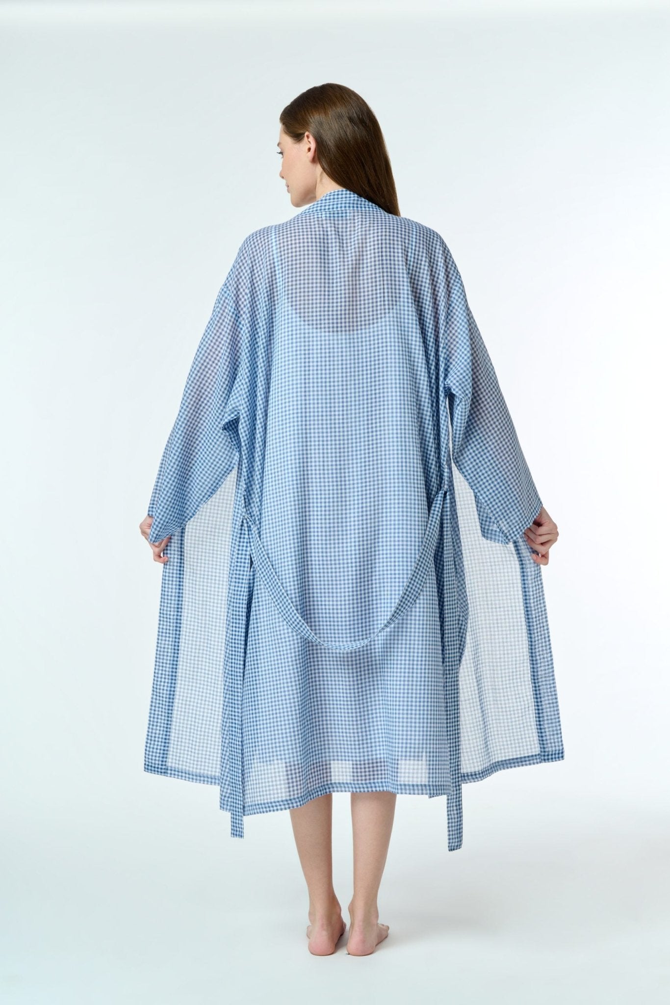 navy gingham cotton robe, shown tied at the waist, highlighting the soft drape and hand-loomed fabric texture.