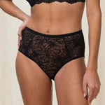 Model in full standing pose wearing Triumph shaping brief with high-cut leg and ribbed waistband.