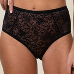 Close up of Model wearing Triumph Amourette Charm Maxi 02 Brief in black, showing floral lace detail and wide sides.