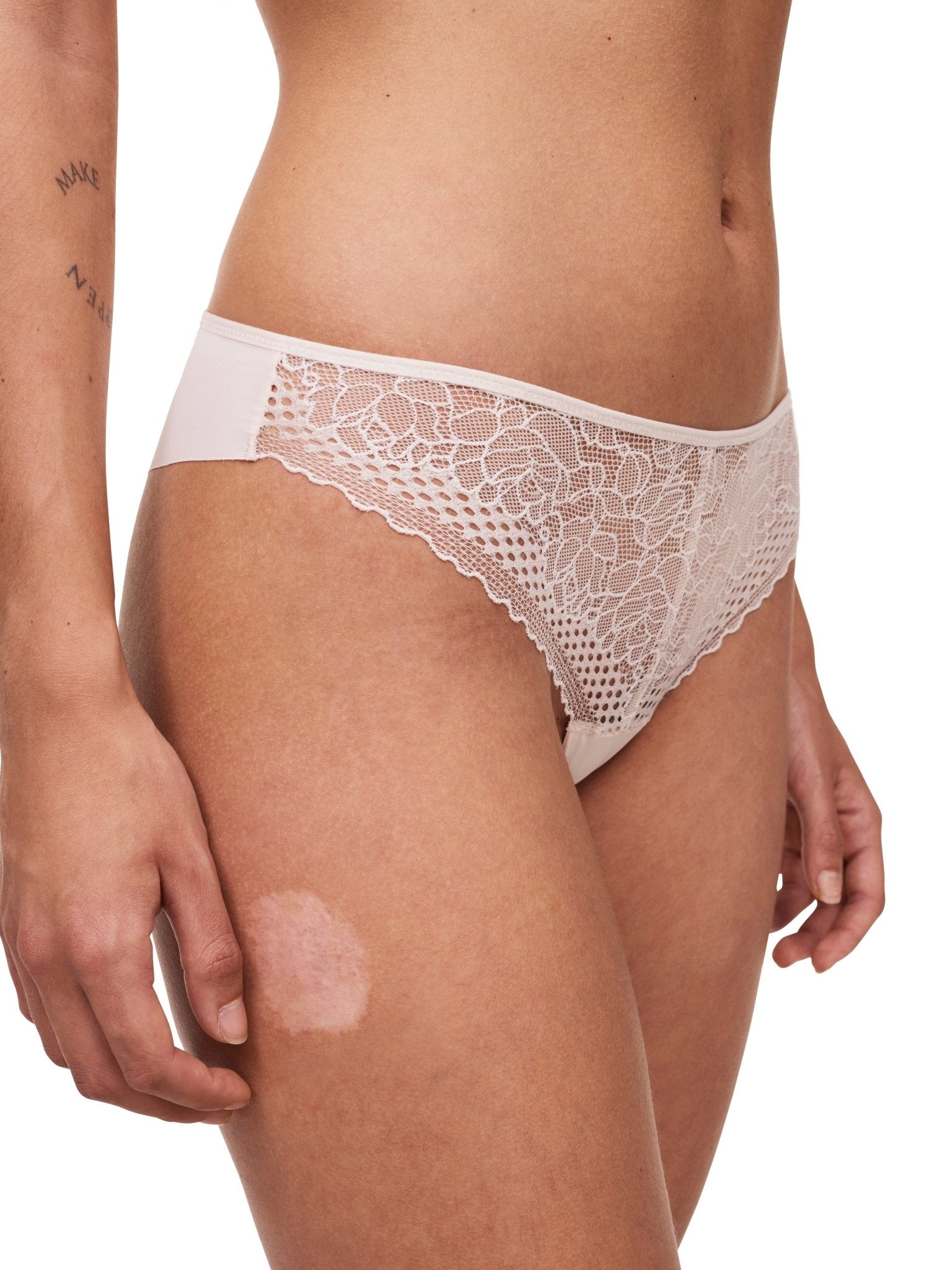 Side view of the Pila Tanga Brief in Talc, featuring sheer lace front and fishnet waistband – from The Foundation.