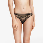 Model wearing Maddie Tanga Brief in black showing delicate floral lace and lace-trimmed waistband.