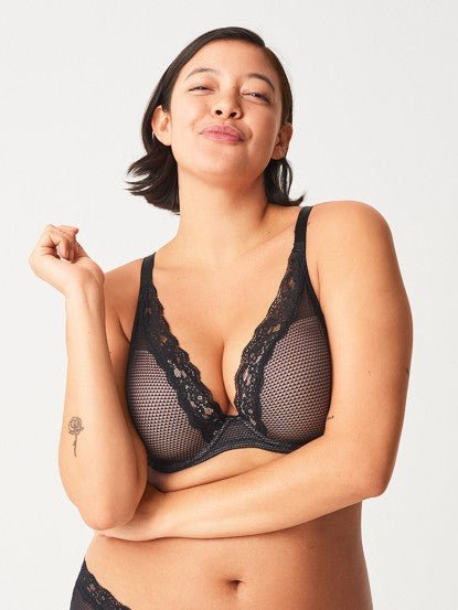 Model in Passionata Brooklyn Plunge T-Shirt Bra in Black from The Foundation, with low centre plunge, foam underwire cups, and smooth lace detail. front view