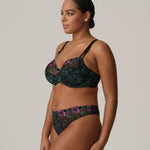 Side profile of model in Prima Donna San Angel Thong Brief Peacock Feather, displaying high-leg cut and colourful Swiss embroidery from The Foundation.