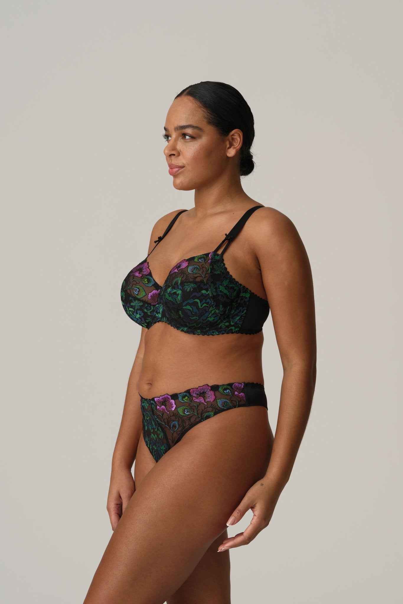 Side profile of model in Prima Donna San Angel Thong Brief Peacock Feather, displaying high-leg cut and colourful Swiss embroidery from The Foundation.