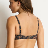 Woman wearing a leopard print bikini against a plain background