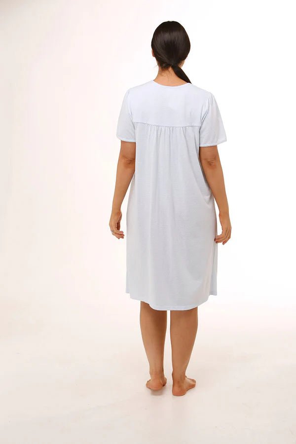 Back view of Schrank Embroidered Short Sleeve Nightie Blue, model showing soft gathering and short length, featured at The Foundation.