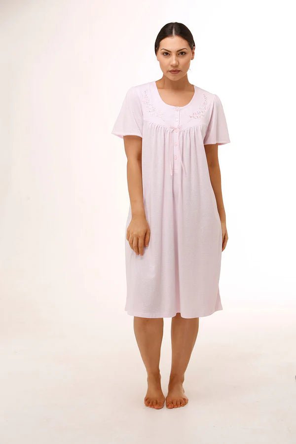 Model wearing Schrank Embroidered Short Sleeve Nightie Pink, front view, showcasing soft jersey knit fabric and delicate embroidery, available at The Foundation.