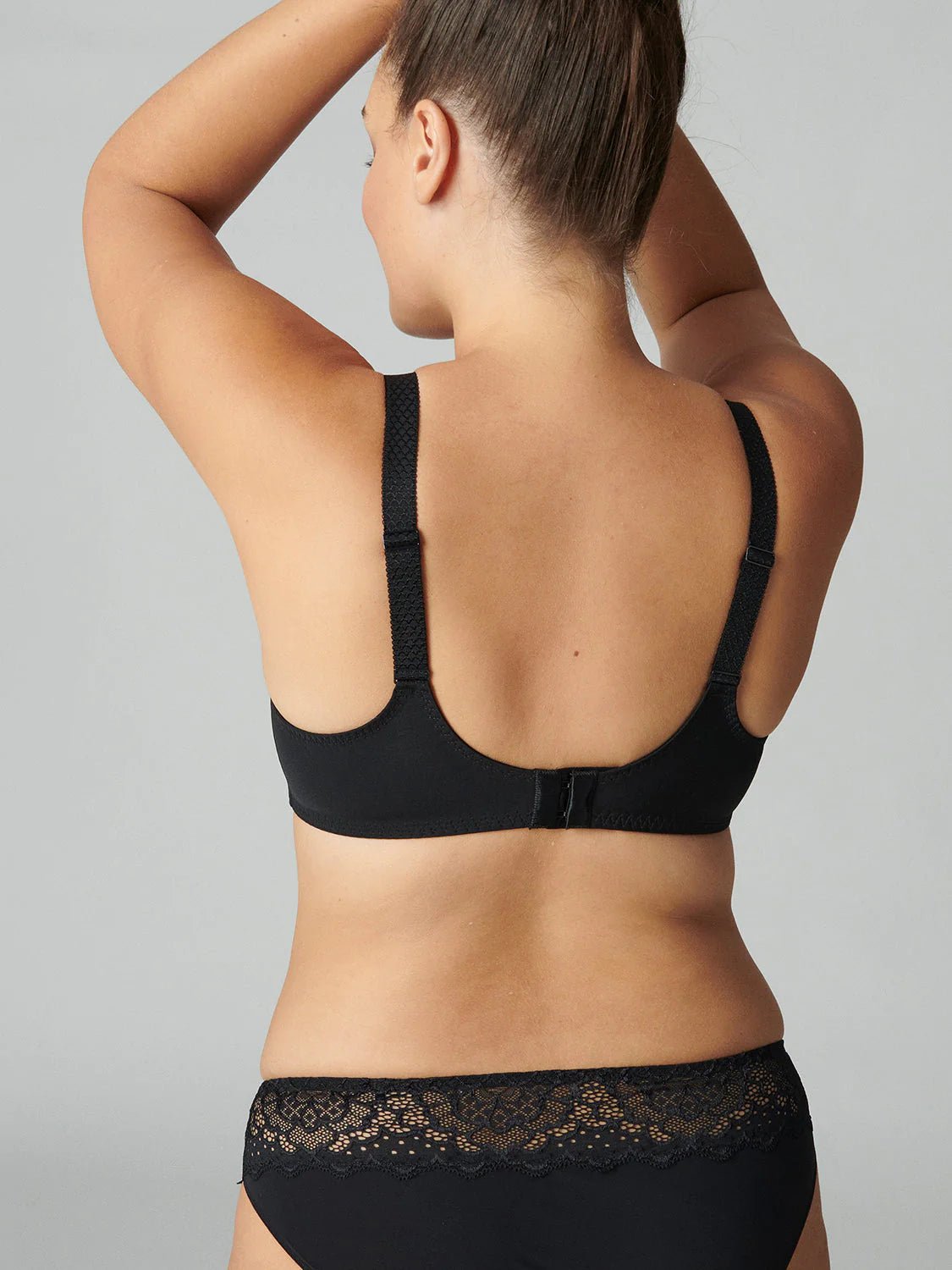 Model wearing Simone Pérèle Caresse Full Cup Bra in Black from The Foundation, featuring 3-part supportive cups, lace finish, and cotton lining. back view