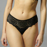 Simone Pérèle Caresse Shorty Brief in Black, worn by model, featuring low-rise silhouette with scalloped lace trim.