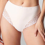 Model wearing Simone Perele Delice Culotte Brief in blush – lace detailing and high-cut leg visible.