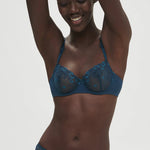 Model wearing Simone Perele Delice Half Cup Bra in Prestige Blue, sheer embroidered lace demi cup.