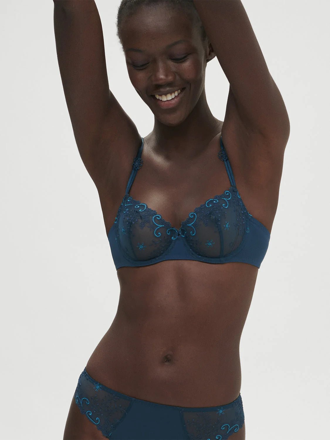 Model wearing Simone Perele Delice Half Cup Bra in Prestige Blue, sheer embroidered lace demi cup.