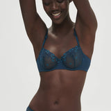 Model wearing Simone Perele Delice Half Cup Bra in Prestige Blue, sheer embroidered lace demi cup.