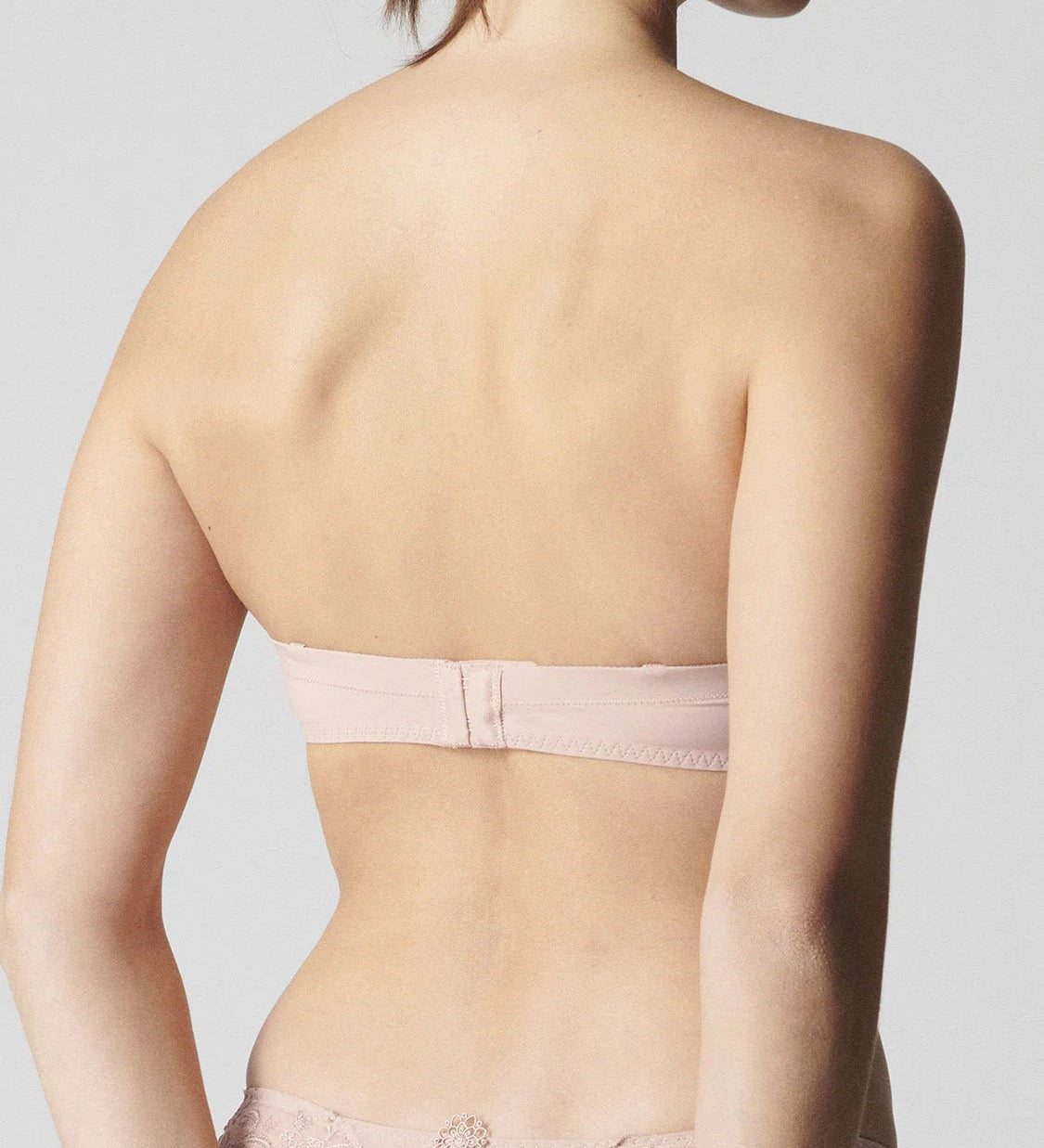 Back view of blush strapless bra by Simone Perele – smooth silhouette with adjustable, removable straps