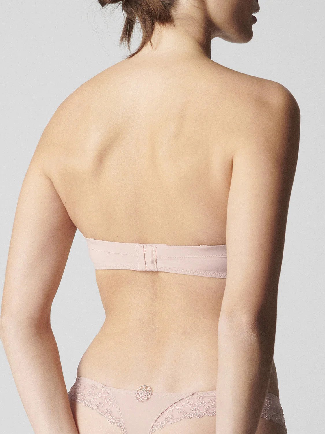 Back view of blush strapless bra by Simone Perele – smooth silhouette with adjustable, removable straps