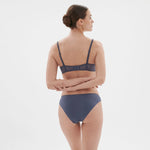 Side and back view of Intrigue Bikini Brief Cinder Blue on model, displaying fit and comfort from The Foundation.