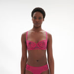 Model wearing Intrigue Half Cup Bra Disco Pink by Simone Perele, front view displaying embroidery and sheer tulle from The Foundation.