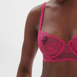 Side profile of model in Intrigue Half Cup Bra Disco Pink by Simone Perele, showing soft straps and fit from The Foundation.