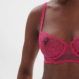 Side profile of model in Intrigue Half Cup Bra Disco Pink by Simone Perele, showing soft straps and fit from The Foundation.
