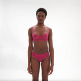 Model wearing Intrigue Tanga Disco Pink by Simone Perele, front view showing embroidered tulle and scalloped edges from The Foundation.