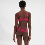 Back view of Intrigue Tanga Disco Pink by Simone Perele, showcasing sheer tulle and sexy cut from The Foundation.