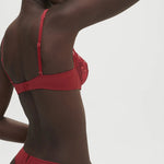 Model wearing Saga Half Cup Bra Lipstick from The Foundation, angled front to show deep plunging neckline and elegant lace