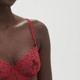 Side view of model in Saga Half Cup Bra Lipstick from The Foundation, featuring wide-set straps and supportive underwire fit