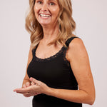 Model wearing TBL Modal Camisole with Lace Trim in black, showing soft stretch fit and thermal layering option for women.
