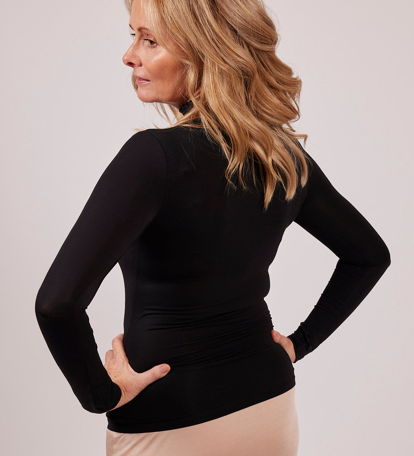 Side profile of black modal EGI polo neck top showing flattering stretch and smooth texture.