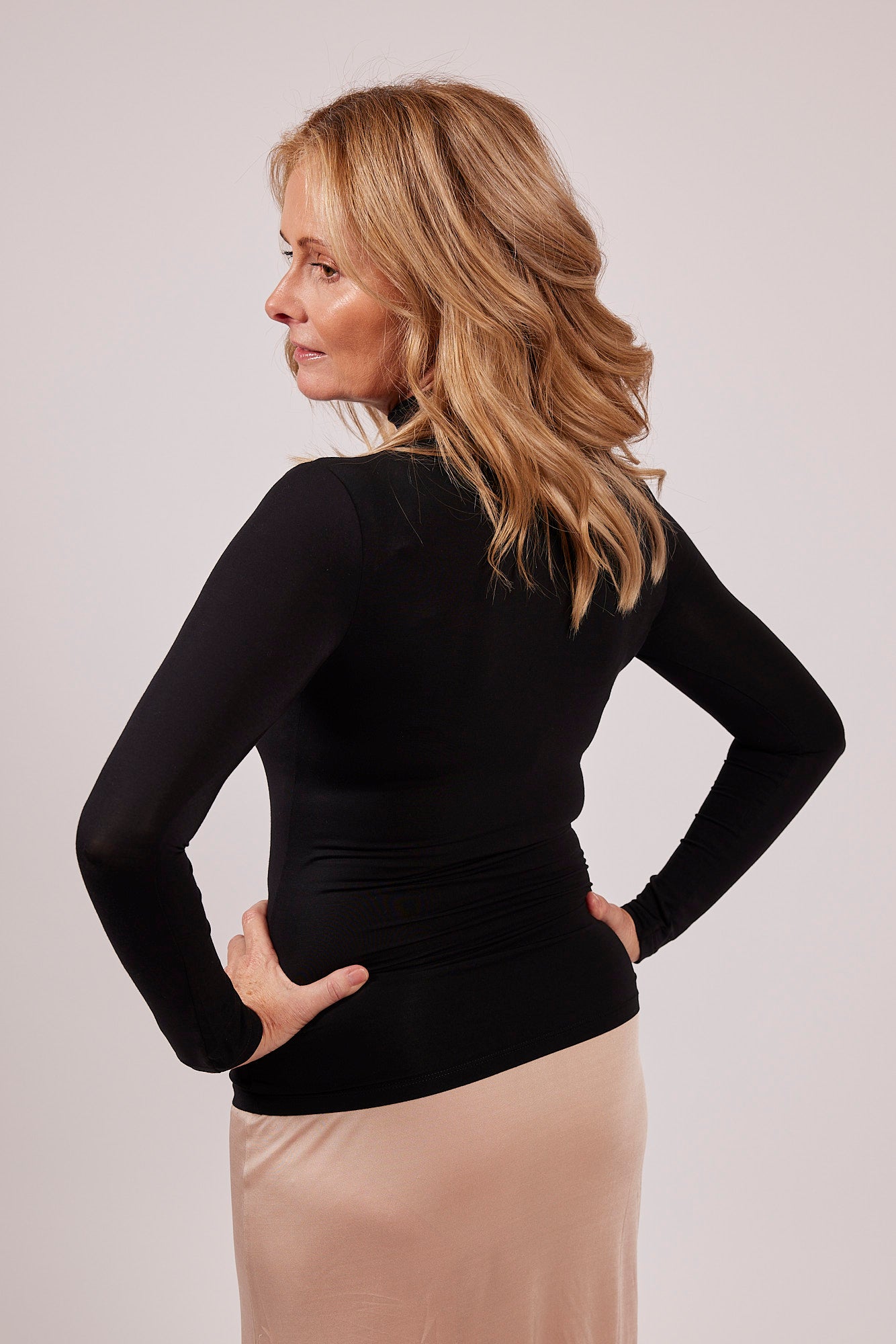 Side profile of black modal EGI polo neck top showing flattering stretch and smooth texture.